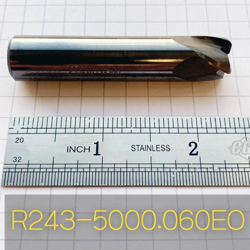 Refurbished End Mills R243-5000.060EO, cylindrical metal cutting tool with helical cutting edges, placed on a measuring scale for size reference.