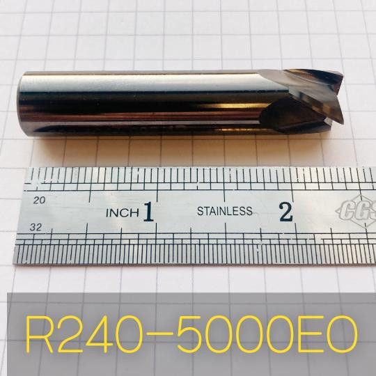 Refurbished End Mills R240-5000EO, cylindrical metal cutting tool with a spiral flute, placed on a measurement grid for scale.