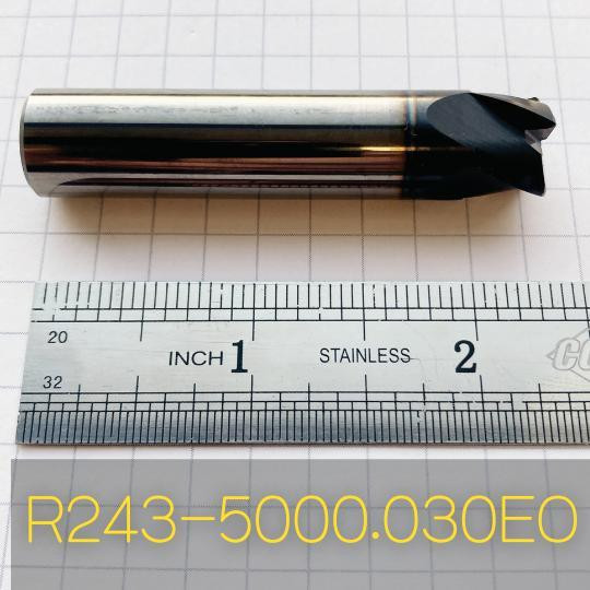 Refurbished End Mills R243-5000.080EO, cylindrical metal cutting tool with black cutting edges on a measurement grid background.