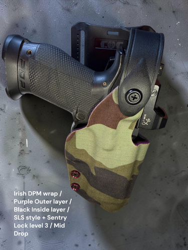 Top-down view of a dual-layer mid-drop OWB holster with Irish DPM fabric wrap, purple outside layer, black inside layer, SLS-style hood with Sentry Lock Level 3 retention, and optional QLS fork and receiver mounting system.