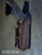 Side profile of an OWB Level 3 retention holster with dark brown leather wrap, black Kydex construction, and SLS plus Sentry Lock retention.