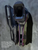 Rear angle of a dual-layer mid-drop OWB holster featuring Irish DPM fabric wrap, purple outside layer, black inside layer, SLS-style Level 3 thumb break, and optional QLS fork and receiver attached to the mid-drop platform.