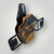 Close Quarters Carry dual-layer holster wrapped in embossed brown floral leather, shown equipped with a Qualifier Strap for OWB carry conversion. Features visible hardware posts and precision detailing.