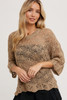 Picture of woman wearing a light brown open weave sweater with 3/4 sleeves