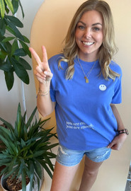 Picture of woman wearing a blue graphic tee that reads "you are enough"