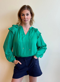 Picture of woman wearing a long sleeve emerald green blouse