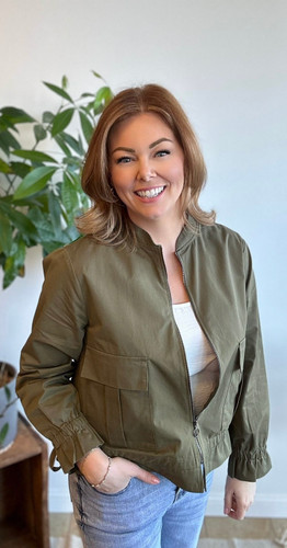 Picture of woman wearing an olive zip up spring jacket