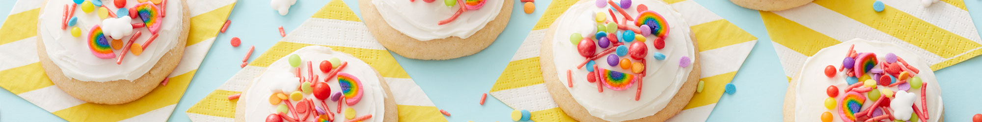 cookies iced with rainbow sprinkles on striped napkins