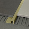 A solid brass  square edge tile trim for uncoupling two floor sections at the same level.