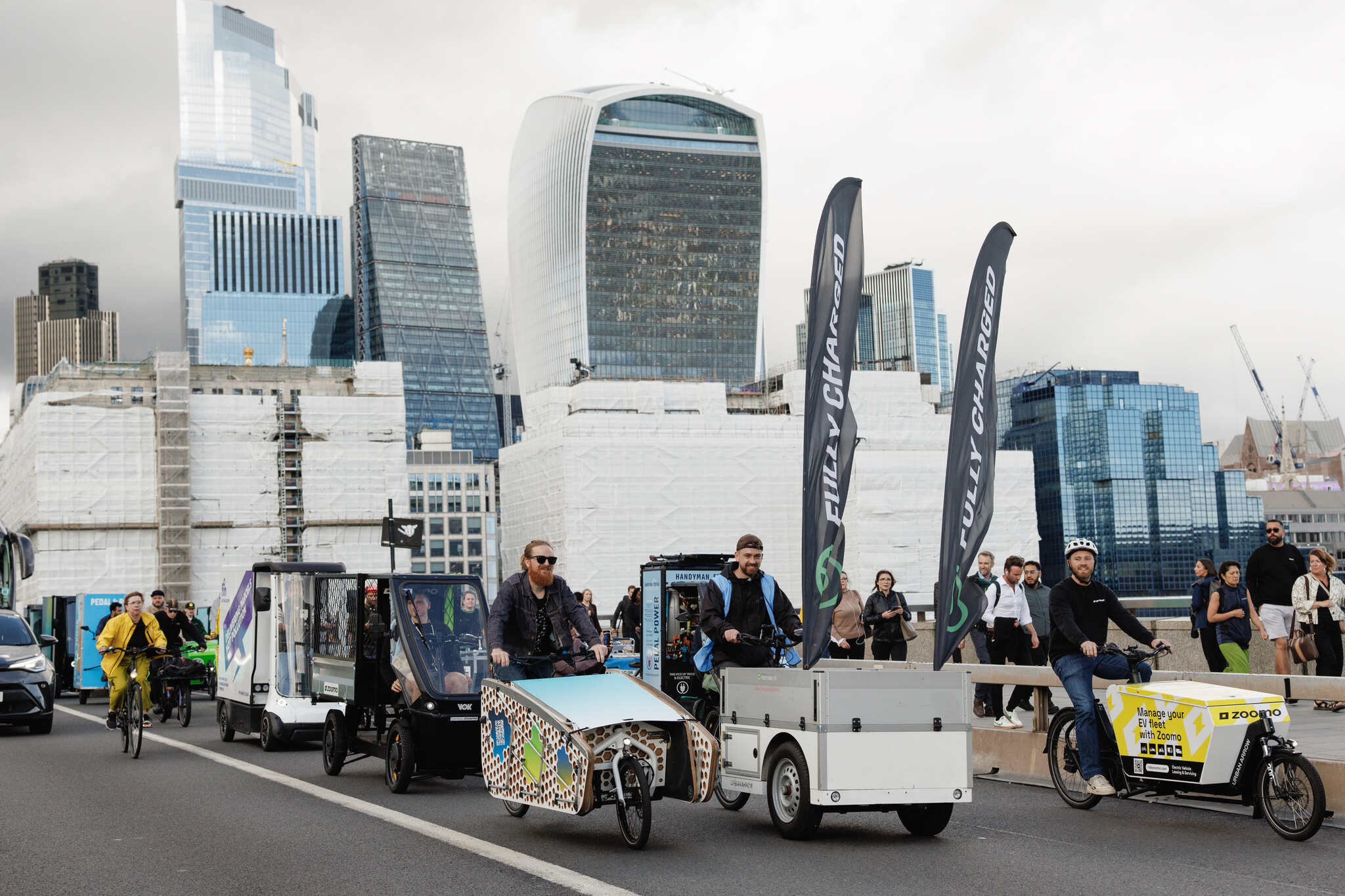 Vok Bikes Black electric cargo tricycle with enclosed storage Modern glass building background