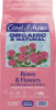 Front packaging of a bag of Coast of Maine fertilizer against a solid white background. The bag is light pink with a prominent light blue and dark blue label block near the top. Cursive white text reads "Coast of Maine," followed by large dark purple text reading "ORGANIC & NATURAL." Below the brand name is an illustration of pink roses growing on green stems with leaves. The lower half of the bag displays text reading "FERTILIZER FOR Roses & Flowers" with the chemical formula "4-6-5 (6% Calcium 4% Sulfur)" and the claim "PROMOTES FLOWERING & BUDDING." Three small white line drawings illustrate a rose, perennials, and annuals next to an icon reading "100% OCEAN & LAND INGREDIENTS." The bottom corner lists "NET CONTENTS 4 LBS (1.81KG)" alongside a product barcode.