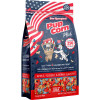 A front product photograph of a Star-Spangled Pup Corn Plus dog treats pouch set against a white background. The dark blue bag features an American flag design at the top, a cartoon Dalmatian pushing a popcorn cart, and a transparent window at the bottom showcasing red, white, and blue star-shaped dog treats.