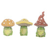 A front product photograph showcasing three different styles of miniature decorative green frog figurines wearing mushroom caps as hats, arranged horizontally against a white background. The collection features a frog with a rounded orange mushroom cap, one with a wide yellow cap, and one with a tall, curled red mushroom cap, all detailed with white spots.