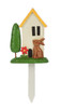 A front product photograph of a single miniature decorative garden house pick isolated against a white background. The resin stake features a small cream-colored cottage with a yellow roof, a tall green tree, a red flower, and a small brown rabbit sitting on a patch of green grass attached to a white plastic ground stake.