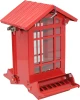 A red house-style metal squirrel-proof bird feeder with clear window panes, a pitched roof, and a weight-activated perching tray, isolated on a white background.