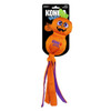 An orange and purple KONG Wubba Halloween pumpkin dog toy mounted on a black retail card, featuring an embroidered jack-o'-lantern face, a green leaf stem, and dangling fabric tails.