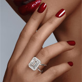 Emerald Cut Halo Engagement Ring with a Platinum Axis Setting on hand