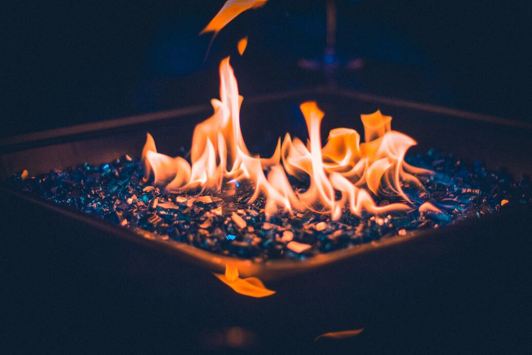 A lit fire pit with fire glass