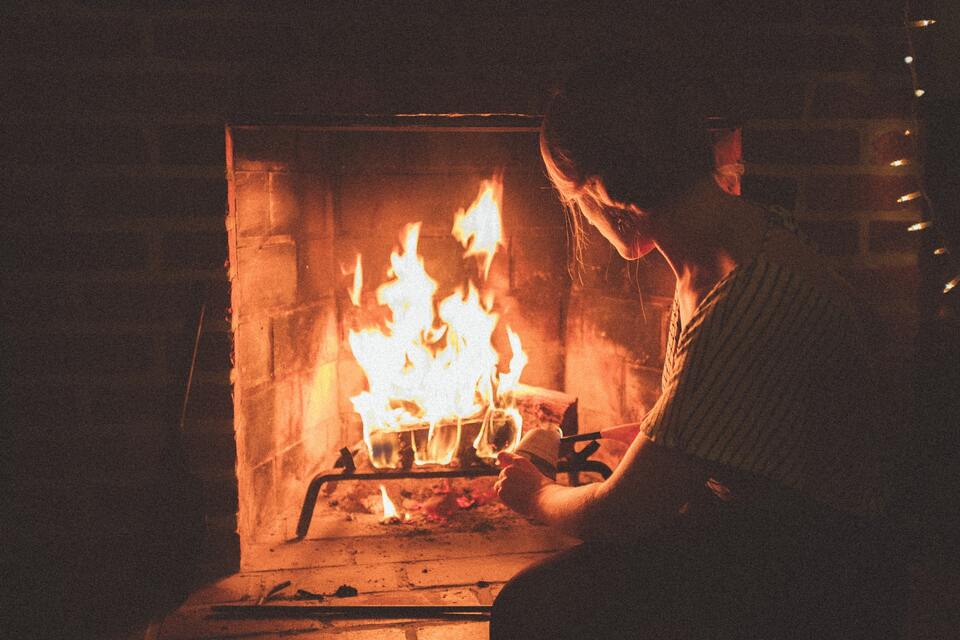 A woman sitting in front of a fireplace