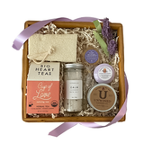 Big Heart Tea basket filled with comfort.  Calm bath salts, Unwined Candle, Big Heart Herbal Teas, with Honey lollipop, soothing shower steamer and loofah.