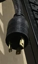 Close-up view of the NEMA L5-20P twist-lock power plug attached to an APC Rack PDU.
