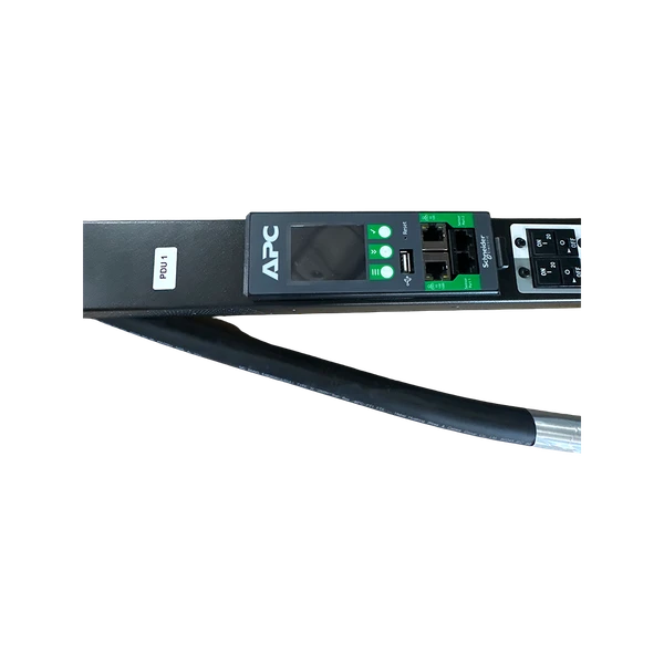 Close-up of an APC by Schneider Electric PDU management module showing the LCD screen interface, network ports, resetting pinhole, label marked "PDU 1", and circuit breakers.