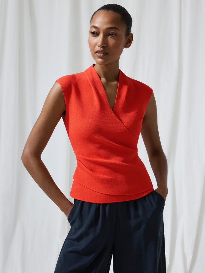 Model wearing vivid orange Eldia top