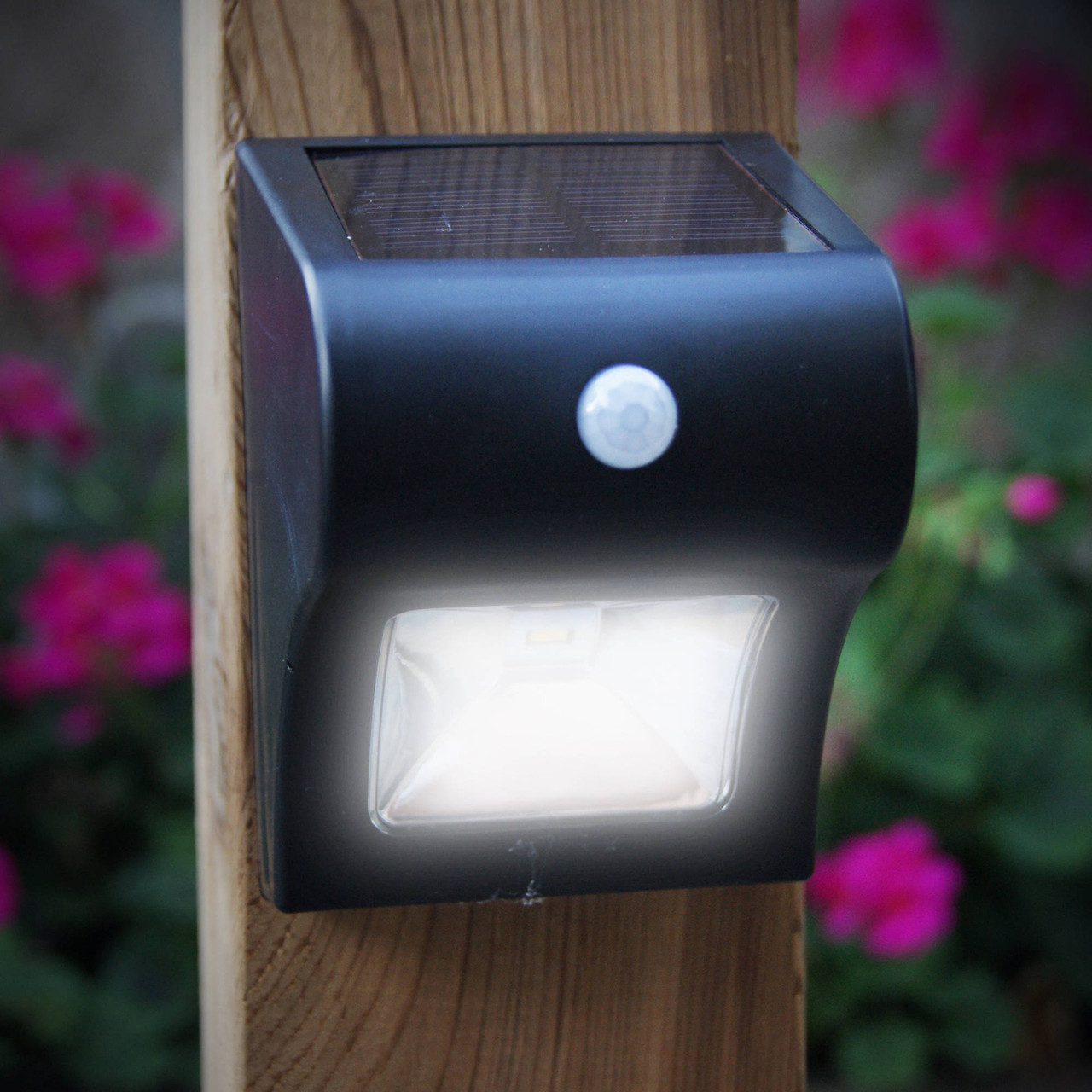 Black Solar Motion Sensor Deck & Wall Light from Classy Caps on a Wood Post