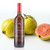 Tarpon Springs Olive Oil Company Pink Guava Rosé Balsamic bottle with fresh whole and sliced pink guavas on a white background