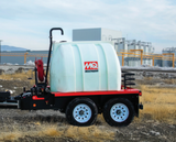 Angled shot of the trailer parked on gravel, capturing the full layout including the tank, trailer frame, and pump assembly.