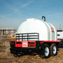 Wide-angle image of the trailer in a jobsite environment, presenting the full unit ready for water transport and spray operations.