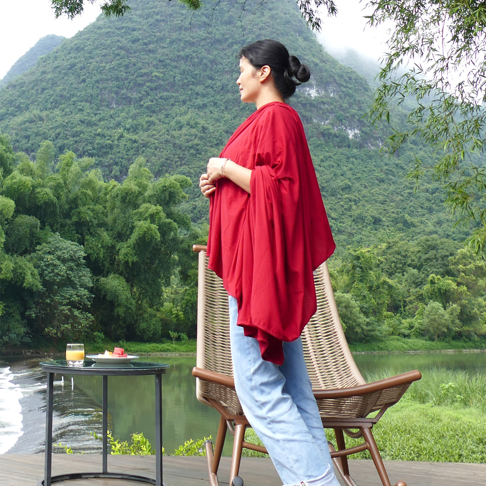 Person covered in a travel sentry by a lake