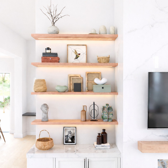 1 5/8-inch thick solid red oak floating shelves with integrated LED lighting, installed in a modern living space. The illumination highlights the wood’s rich grain variation and organic character while adding both function and refined visual interest.