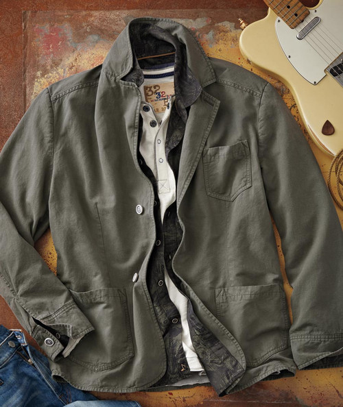 32 Bar Blues Right For The Time, clothing and guitar accessories laid out on a rustic surface, featuring a green casual jacket, layered shirts, and an electric guitar.