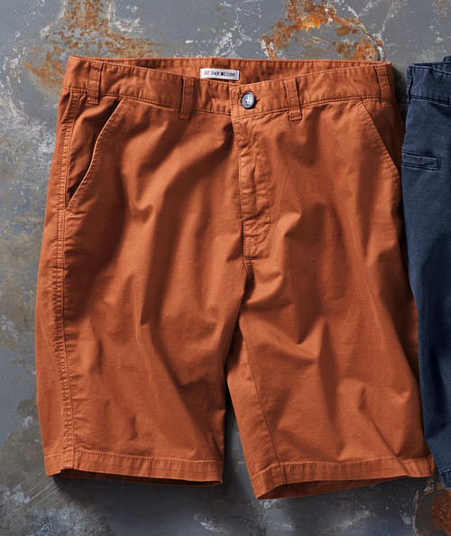 32 Bar Blues Good Idea shorts, brown casual men's shorts with front pockets lying on a textured, rusty surface.
