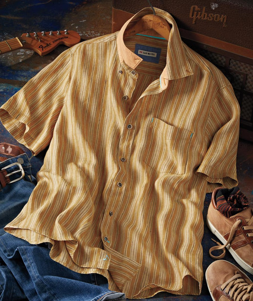 32 Bar Blues Do You Feel It? - Vintage casual outfit with a striped short-sleeve shirt, denim jeans, brown leather belt, sneakers, and an electric guitar on a rustic wooden surface.