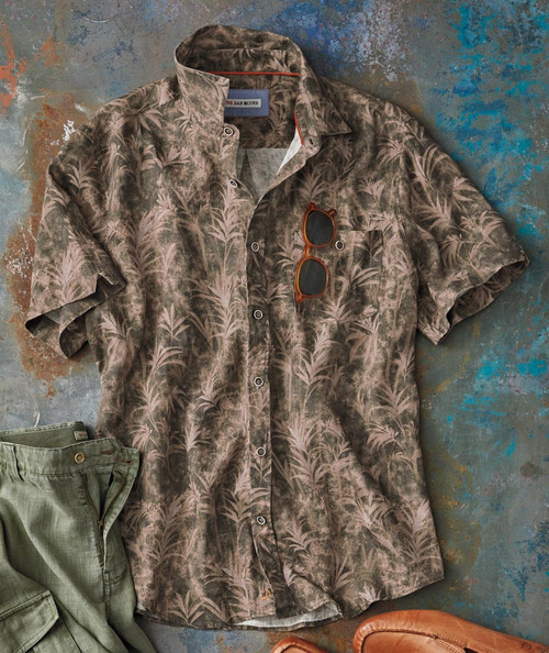 32 Bar Blues Funcalypso, a patterned short-sleeve button-up shirt with leaf designs, paired with sunglasses and green pants on a textured background.