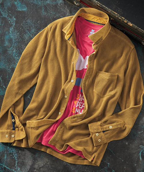 32 Bar Blues That's Rich, Man - A stylish outfit featuring a brown corduroy shirt layered over a vibrant pink graphic t-shirt on a textured dark background.