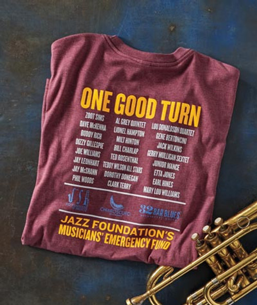 32 Bar Blues Let's Do It Again T-shirt with jazz group list and 'One Good Turn' headline, placed next to a saxophone on a blue surface.