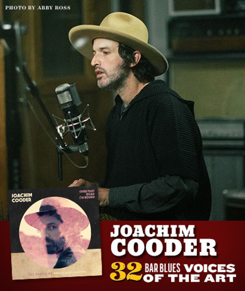 32 Bar Blues Over That Road I'm Bound by Joachim Cooder, musician recording in a studio with a microphone, wearing a beige hat and black sweater.