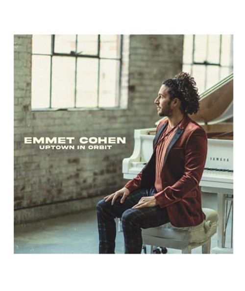 32 Bar Blues Emmet Cohen - Uptown in Orbit, a jazz album cover featuring Emmet Cohen sitting at a white piano in an industrial-style room with large windows.