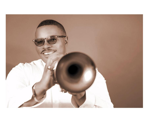 32 Bar Blues Jeremy Pelt - Griot: Examining The Lives Of Jazz's Great Storytellers, a portrait of a talented jazz musician playing the trumpet with a warm background.