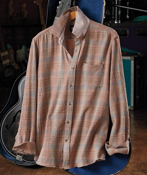 32 Bar Blues Active Ingredients, a long-sleeve button-up shirt hanging on a hanger in a music store.