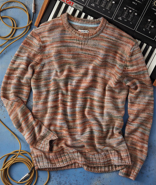 32 Bar Blues Siesta At The Fiesta, Warm multicolored striped sweater lying on a surface with musical instrument accessories and a keyboard in the background.