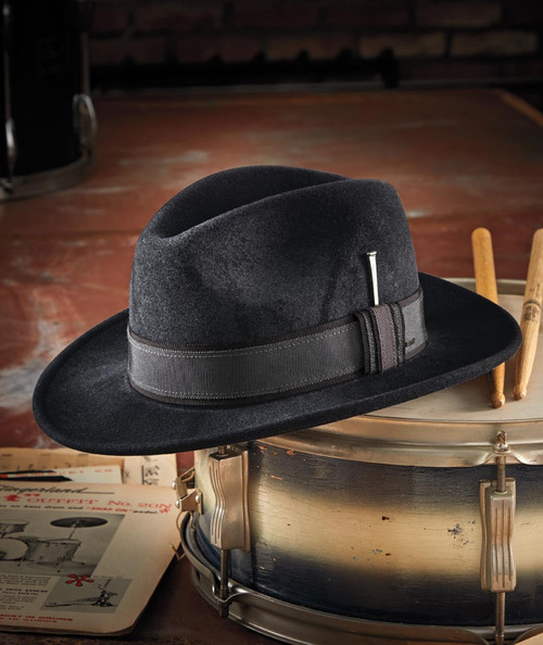 32 Bar Blues The Unifier, a black felt fedora hat with a decorative ribbon band resting on a snare drum.