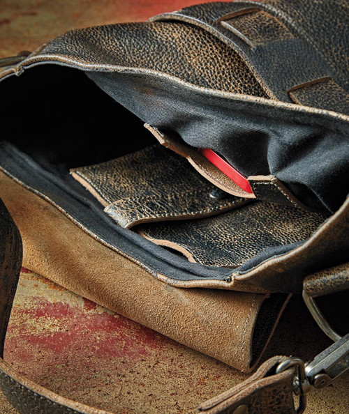 32 Bar Blues You Better Go Now, close-up of an open vintage leather bag with a red harmonica inside, on a worn rustic surface.