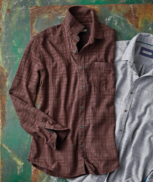 32 Bar Blues You're The Difference, men's button-up shirts with plaid patterns in brown and gray colors laid flat on a distressed wooden surface.