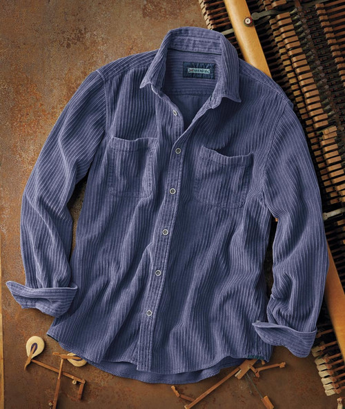 32 Bar Blues Smile Like That, a men's blue corduroy button-up shirt with chest pockets and rolled-up sleeves, laid on a rustic surface.