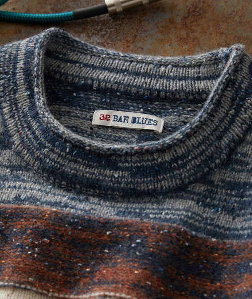 32 Bar Blues Groovy Samba, close-up image of a blue speckled sweater with a clothing tag showing the brand name 32 Bar Blues.