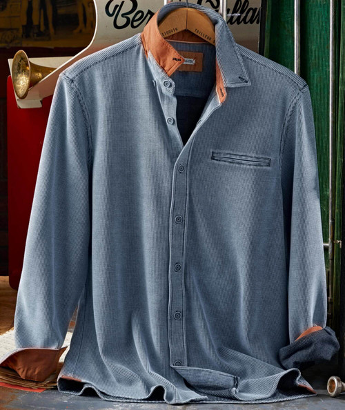 32 Bar Blues Bloozey, stylish men's blue checkered casual shirt with contrasting brown collar and cuffs, button-up front, and a chest pocket, hanging on a wooden hanger.